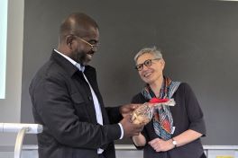 Prof. Mbala receiving a gift from Prof. Low